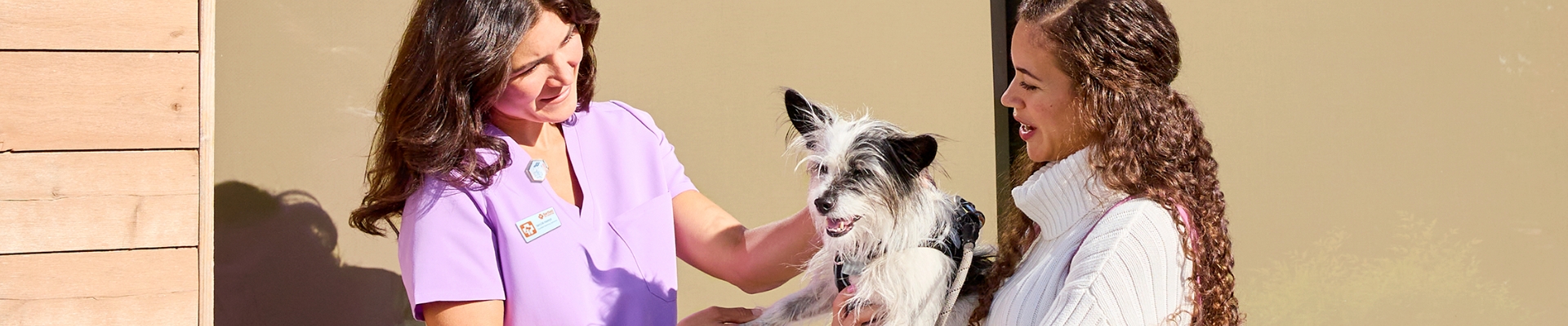Taylor Parker, CVT, greets a customer and her dog outside a Banfield hospital